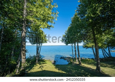 View to the beautiful Lake Manitou from the cabin. Amazing sky line landscape with trees and water. Canadian wilderness. Perfect spot for a holiday. Cottage located on the largest fresh water island. Royalty-Free Stock Photo #2412350335