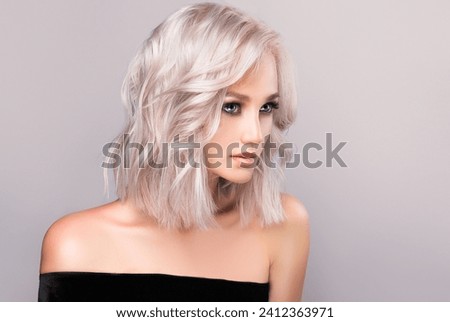 Beautiful girl with hair coloring in ultra blond. Stylish hairstyle curls done in a beauty salon. Fashion, cosmetics and makeup Royalty-Free Stock Photo #2412363971