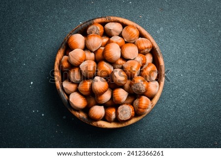 Hazelnuts in a wooden bowl. Hazelnut nut health organic brown filbert autumn background concept. Close up. Royalty-Free Stock Photo #2412366261