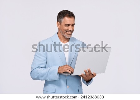 Happy middle aged business man, smiling older professional manager, confident businessman wearing blue suit holding looking at laptop using computer standing isolated on white background.