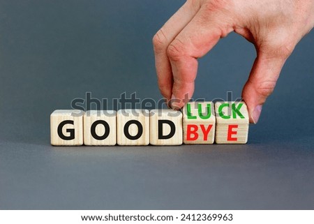Good luck or goodbye symbol. Concept words Good luck or Goodbye on beautiful wooden blocks. Beautiful grey background. Businessman hand. Business, motivational good luck concept. Copy space.