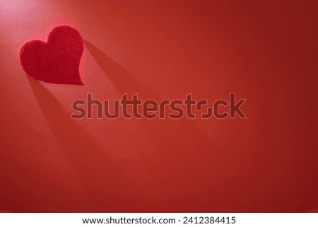 Beautiful heart illuminated from above on a red background