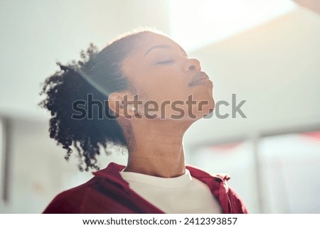 Young healthy fit sporty beautiful African American woman wearing sportswear standing with eyes closed lit with sunlight doing yoga exercises breathing fresh air. Close up. Mental balance concept. Royalty-Free Stock Photo #2412393857