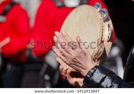 hands of a woman playing a tambourine