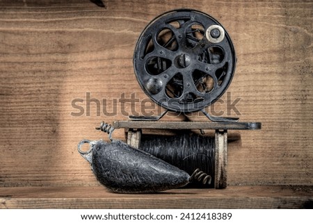 Old fishing reel lead sinker and wire still life Royalty-Free Stock Photo #2412418389