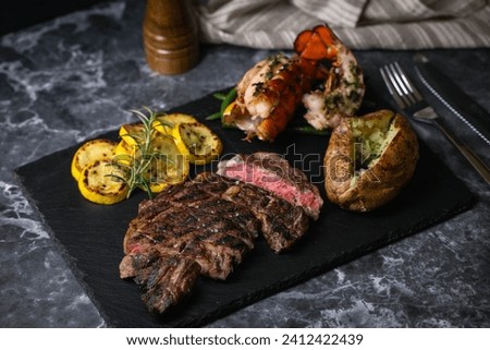 surf and turf, ribeye steak and lobster tail on black marble background