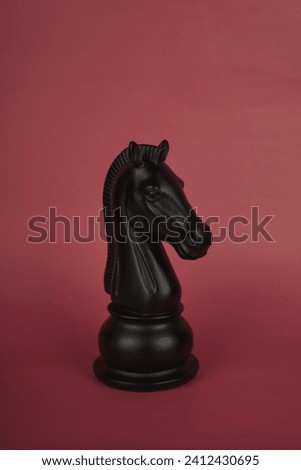 black knight chess piece on a red background