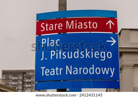 Road sign in Warsaw showing the direction to The Old Town, The Square, Pilsudski Square and The National Theatre  Royalty-Free Stock Photo #2412431145