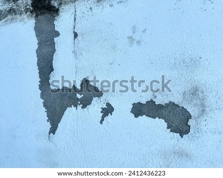 a photography of a dirty wall with a black and white picture of a map.