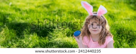 Kids hunting easter eggs. easter basket Boy with easter eggs and bunny ears in backyard. Horizontal photo banner for website header design with copy space for text.