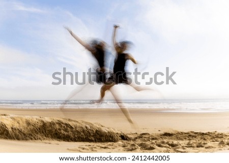 slow motion picture of two girls jumping of rocks into the soft sand, creating star fish blurr in the air