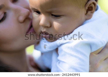 Mothers kiss. Close up portrait of mother kissing multiracial baby. Mother kiss Biracial child, macro. Closeup face of Mother with baby kissing outdoor. Tender moms kiss. Biracial baby and Mother kiss