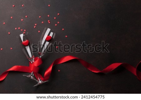 valentine's day greeting card with champagne glasses and candy hearts on black background Royalty-Free Stock Photo #2412454775