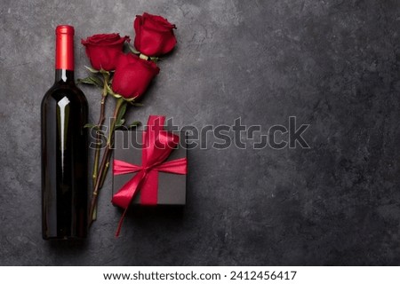 valentine's day greeting card with roses and wine bottle over black background  Royalty-Free Stock Photo #2412456417