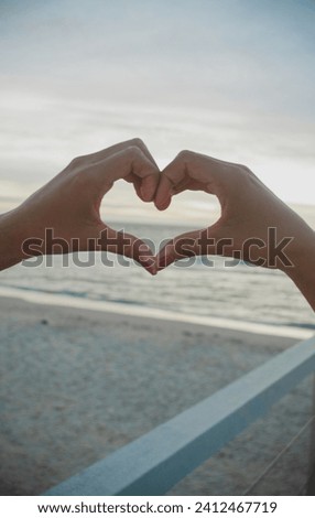 heart shaped hands, beach background
