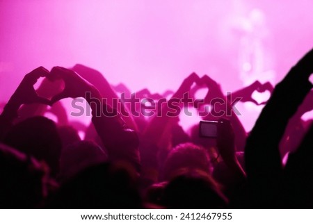 People, heart hands and pink light for music festival for love, support and care for musician. Fans, artist and together with sign, gesture and show for unity, community or solidarity at rock concert Royalty-Free Stock Photo #2412467955