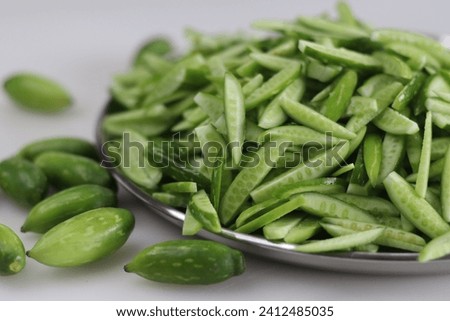 Heap of Ivy gourd or Kovaka vegetables, meticulously sliced lengthwise. Useful for food blogs, menus, and wellness content for promoting healthy lifestyle and farm to table concepts. Royalty-Free Stock Photo #2412485035