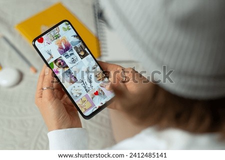 A girl is looking at a photo gallery on her phone. Online social network on a smartphone screen.	