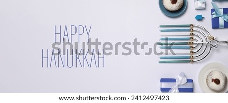 Happy Hanukkah. Menorah, donuts, dreidel and gifts on light background, flat lay. Banner design