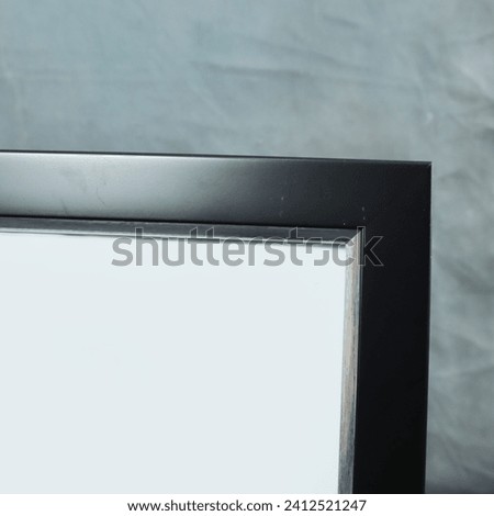 Blank picture frame on gray carpet in the room, close up view
