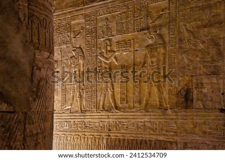 An interior of the temple of Edfu with Egyptian hieroglyphs carved on the walls and columns. Royalty-Free Stock Photo #2412534709