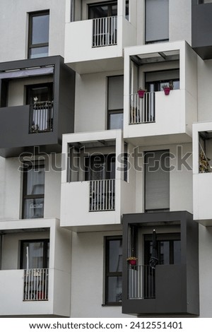 A multi-unit residential building with balconies, located in a vibrant city street