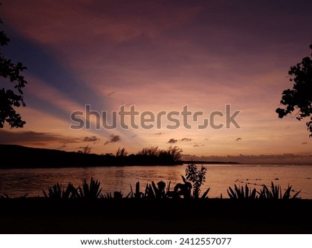A beautiful shot of a bright purple sunset sky over the Runaway Bay, Jamaica Royalty-Free Stock Photo #2412557077