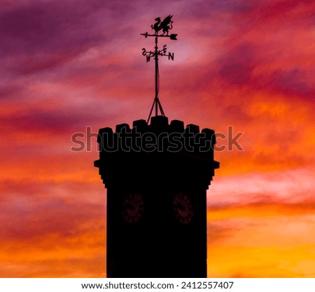 A silhouette of a dragon weather vane of Penrhiwceiber war memorial,Mountain Ash,South Wales at sunset