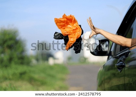 bad habits on the road, environmental pollution. unhealthy behavior by throwing plastic bottles and packaging from the car window while traveling. littering causes environmental damage. Royalty-Free Stock Photo #2412578795