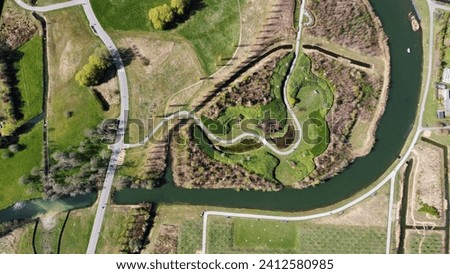 An aerial shot over a beautiful park with biking and skating trails next to a river