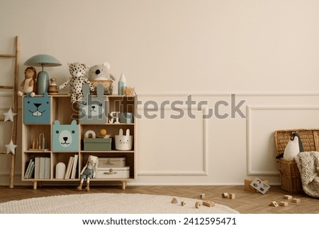 Interior design of kid room interior with copy space, wooden sideboard, round rug, braided basket, beige wall with stucco, plush toys, wooden blockers and personal accessories. Home decor. Template.
