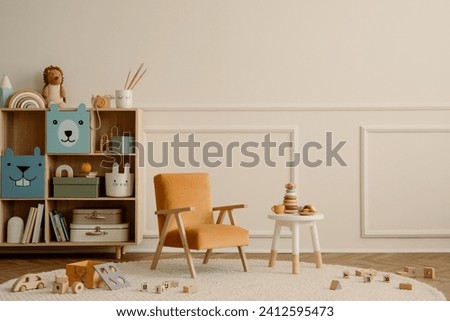 Minimalist composition of kid room interior with copy space, orange armchair, wooden sideboard, round stool, beige rug plush toys, wooden blockers ant personal accessories. Home decor. Template.