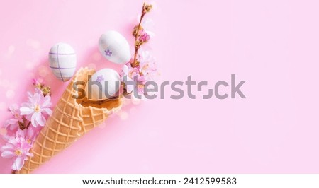 Easter banner with copy space. Easter eggs, cherry blossom flowers, waffle cone on a pink background with bokeh. Church Christian holidays, Christianity, Easter background.