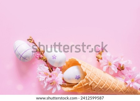 Creative Easter photo with copy space. Easter eggs, cherry blossom flowers, ice cream cone on pink background. Church Christian holidays, Christianity.