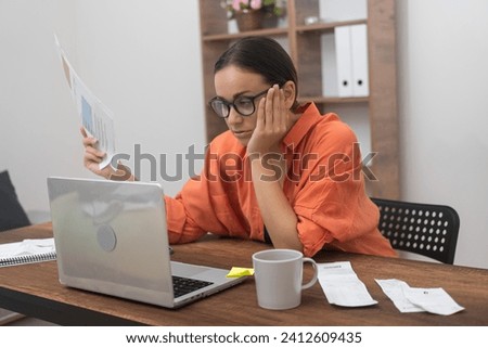 Online Transactions: A woman, weary of boredom, processes domestic bills through a computer app, as a bank customer manages credit insurance payments at home