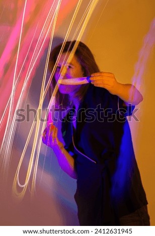Young energetic girl on dancing  party light show at music festival. Attractive pretty girl dancing on festival neon holiday background.
