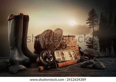 Fly fishing equipment on deck with view of a misty lake background Royalty-Free Stock Photo #2412634389