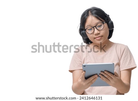 Relaxed asian child preteen pretty girl resting on couch with digital tablet, wearing wireless headset, watching cartoon or nice kids movie on Internet isolated on white, copy space