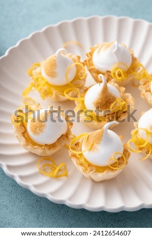 Little lemon meringue tartlets with filo pastry base and lemon curd filling
