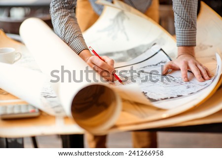 Projecting with pencil on the big urban drawings. Town planning Royalty-Free Stock Photo #241266958