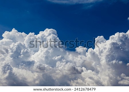 Closeup of Billowy cumulus clouds. Wispy clouds, deep blue sky in background. 
 Royalty-Free Stock Photo #2412678479
