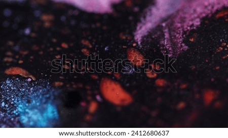 Glitter paint spill. Acrylic wave. Defocused red blue pink black color shimmering particles texture ink water mix flow motion on dark abstract art background.