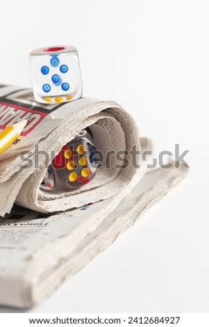 Newspaper and transparent dice on a white background Royalty-Free Stock Photo #2412684927