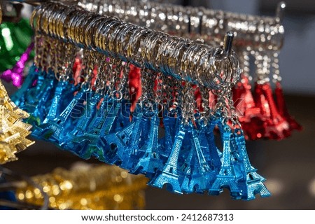colorful Eiffel towers as key rings in a rack at a souvenir shop in Paris