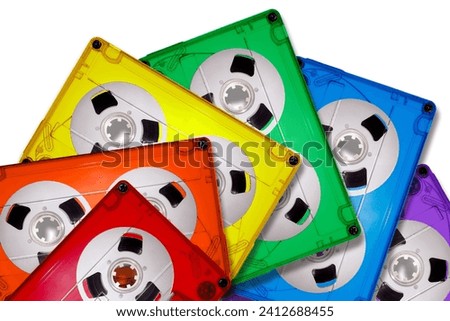 Colored transparent plastic compact audio cassettes lined up in a fan shape on a white background. Bright colors of the LGBT rainbow. The picture is suitable as a background for the music theme.