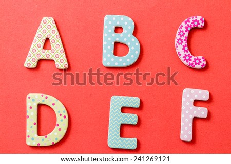 Colorful uppercase letters with beautiful patterns on red background