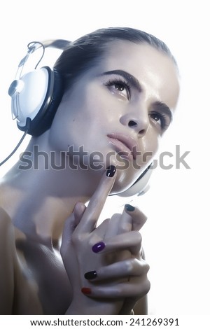 Serene young woman with wet face listening to music in headphones.