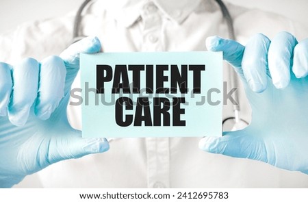 Doctor holding card in hands and pointing the word PATIENT CARE