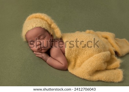 Cute little sleeping African biracial newborn baby sleeping with a knitted yellow hat and wrap Royalty-Free Stock Photo #2412706043
