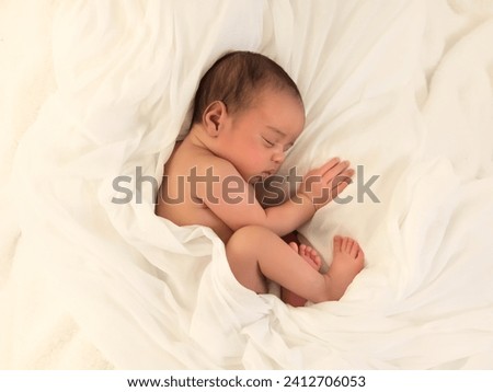 Cute little sleeping African biracial newborn baby sleeping on a white soft blanket Royalty-Free Stock Photo #2412706053
